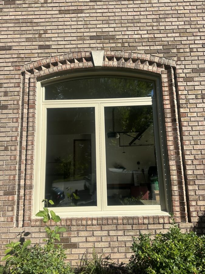 A cream-framed casement built to an arched brick opening