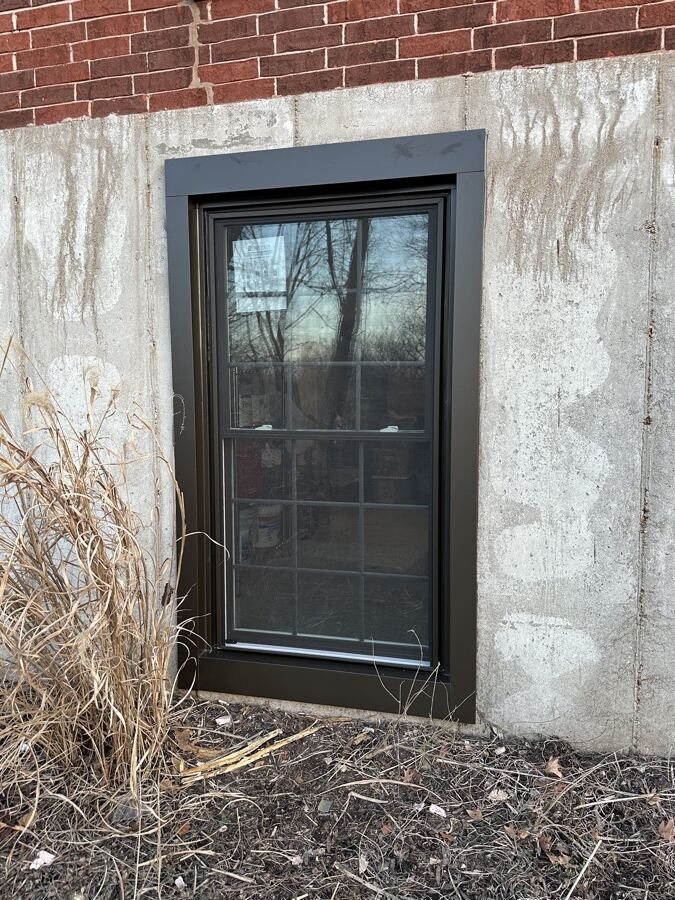 New dark-framed basement window after replacement