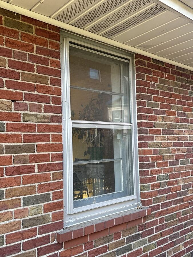 Old single window on a brick house before replacement